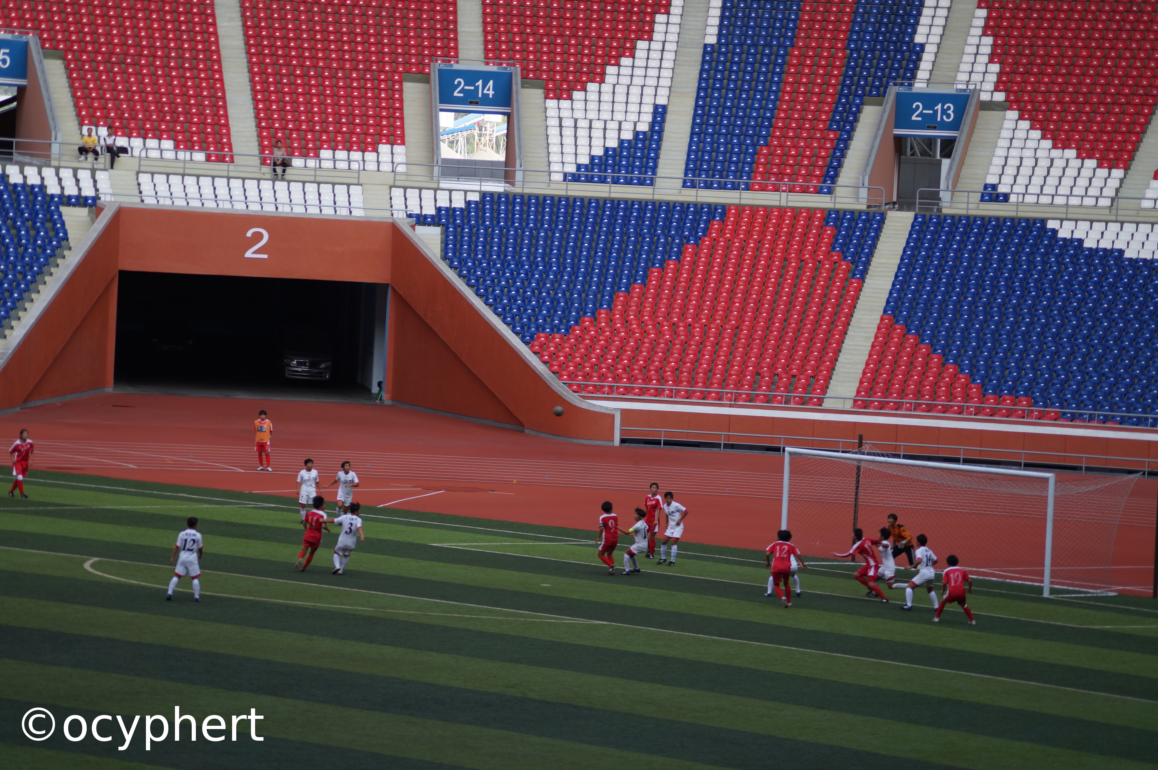 Fußballerinnen spielen auf dem Stadionfeld und erspielen eine Torchance. Das gesamte Stadion ist leer.