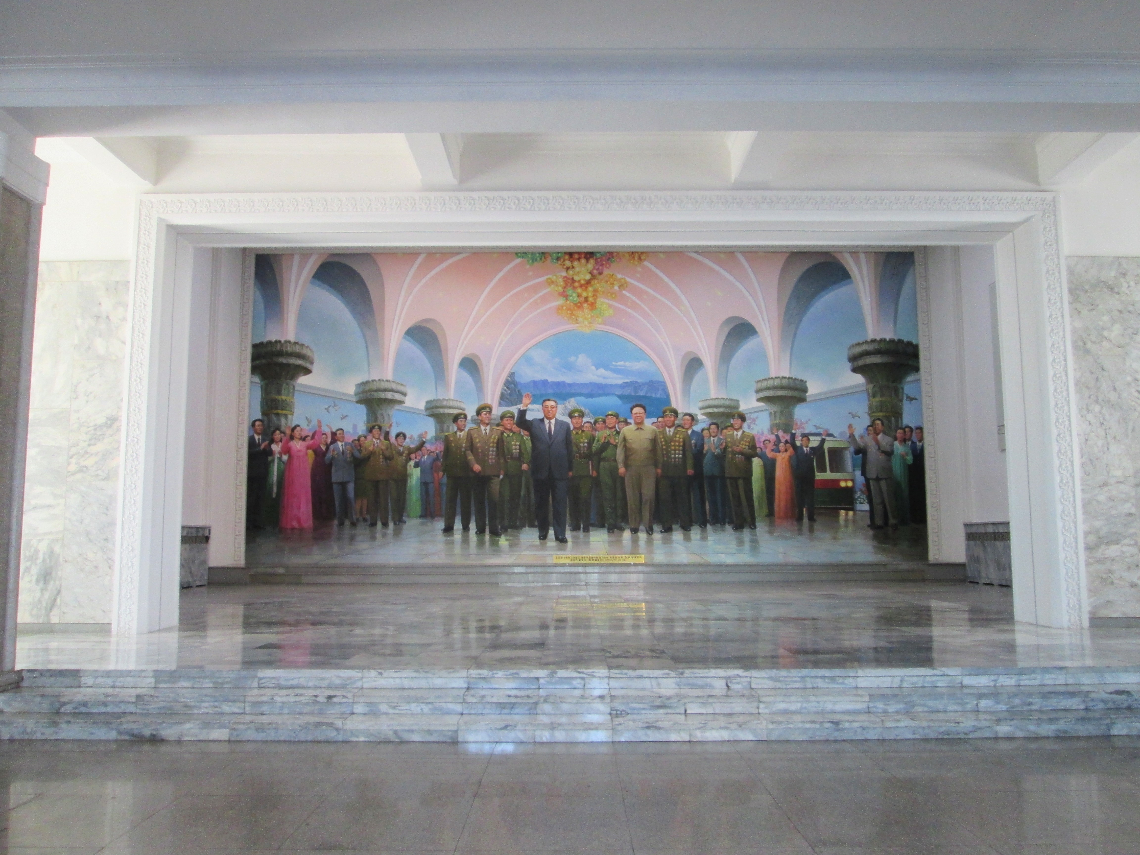 Ein Monumentales Wandgemälde zeigt die verstorbenen Führer Kim Jong Un und Kim Jong Il umgeben von Militär und einer jubelnden Menschenmasse.